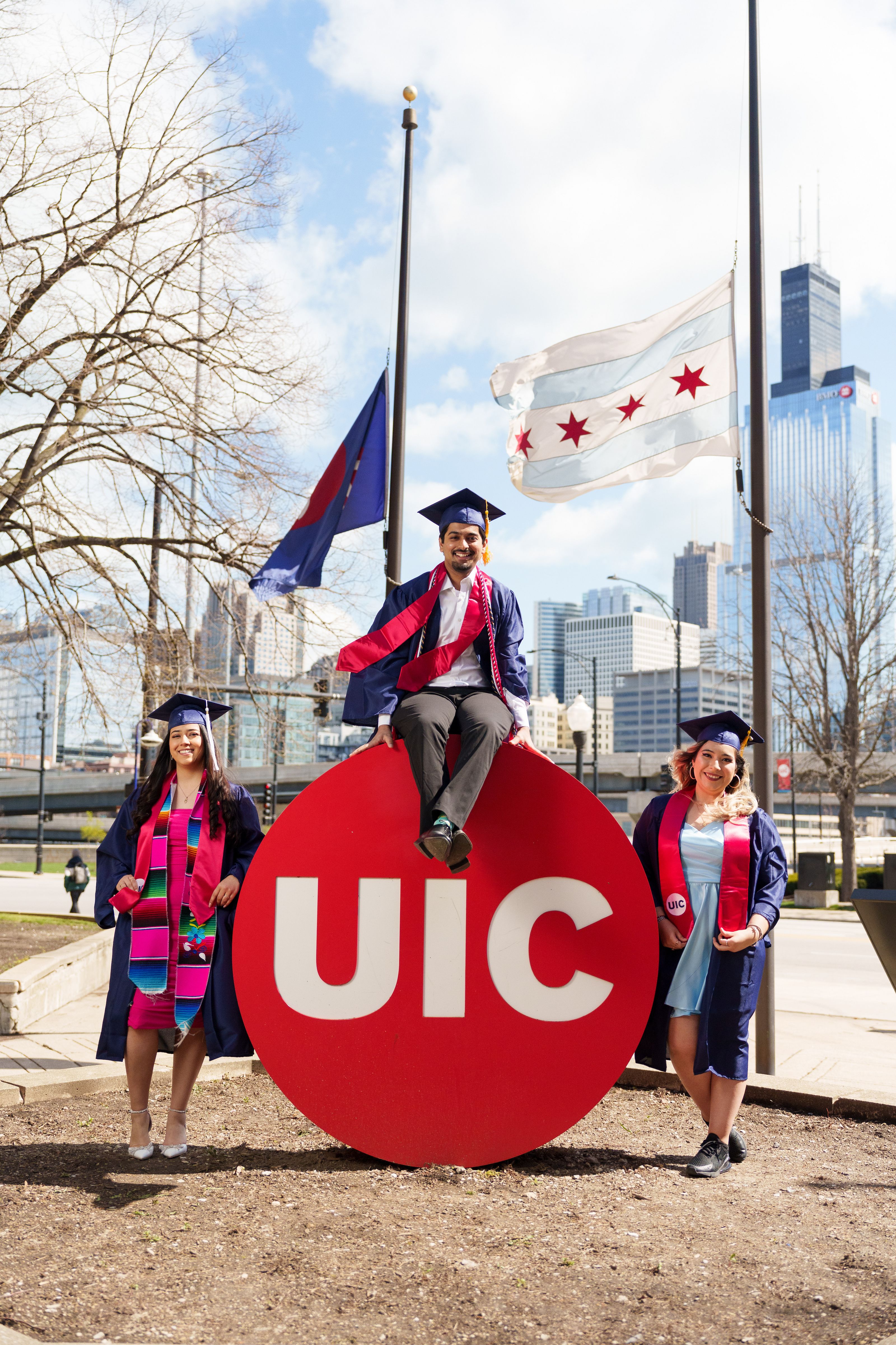 Background image with two graduating student in graduation gown smiling at each other.